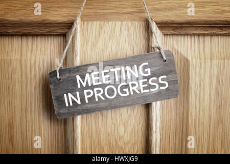Meeting in progress sign on office door concept for business team staff strategy meeting Stock Photo