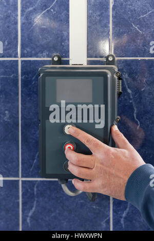 hand pressing keys on the control unit for sliding doors Stock Photo