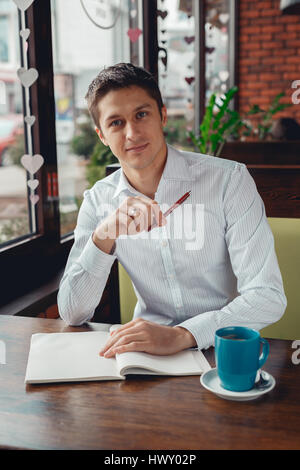 Cheerful young businessman working in cafe Stock Photo