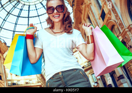 Discover most unexpected trends in Milan. Happy fashion woman with colorful shopping bags in Galleria Vittorio Emanuele II Stock Photo