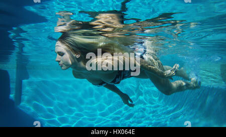 Underwater view of woman in bikini swimming in pool Stock Photo - Alamy