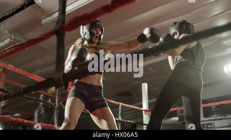 Low angle view of female boxers punching and fighting in boxing ring during match Stock Photo