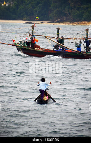 A young girl rows a traditional boat to the village of Makyone Galet, Lampi National Marine Park, Myeik Archipelago, Myanmar Stock Photo