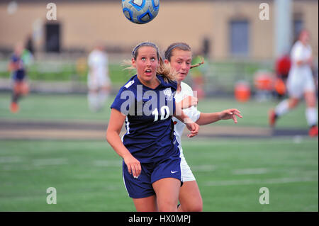 Opposing players battling for control of a loose ball during a high school match. USA. Stock Photo