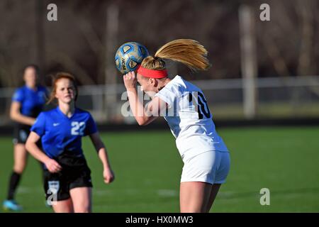 High school player executing a header near midfield. Stock Photo