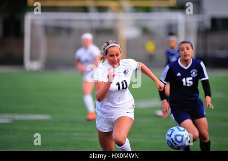 Opposing players racing in a battle for control of the ball. USA. Stock Photo