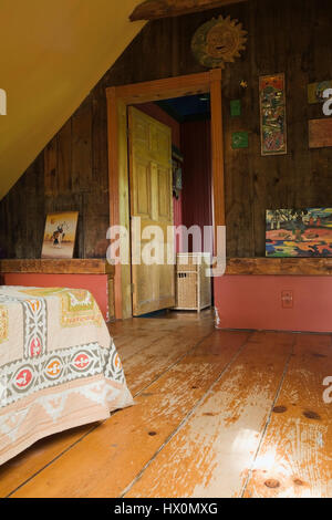 Yellow rustic master bedroom with bed and furnishings in 1840 Canadiana old  house interior. Stock Photo