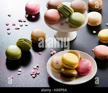 Colorful assorted french macaroons on  dark background. Stock Photo