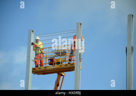 Sonderborg, Denmark - August 2, 2016: Two workers on the platform of a skylift works with a steel construction. Stock Photo