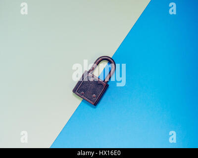 Old little padlock on a colorful blue pastel background. Stock Photo