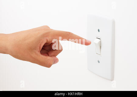 Hand turning light power switch on or off. Stock Photo