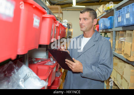 Man in warehouse holding clipboard Stock Photo