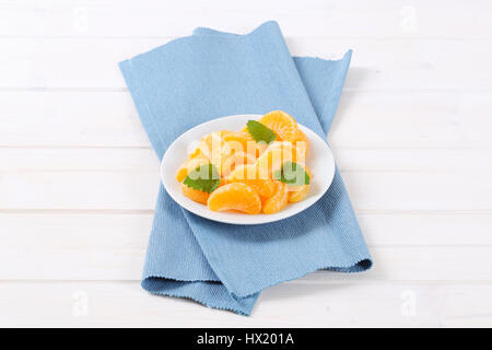 plate of fresh tangerine slices on blue place mat Stock Photo