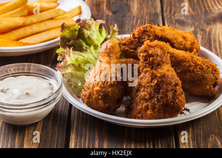 Crisp crunchy golden chicken wings with chips Stock Photo