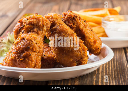Crisp crunchy golden chicken wings with chips Stock Photo