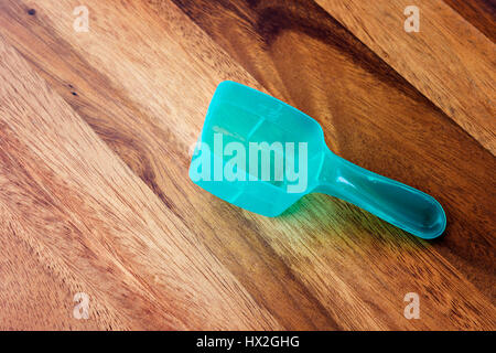 Green measuring spoon closeup on wooden background Stock Photo