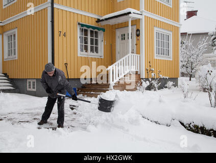 Man Shoveling snow from the villa driveway 2017 Stock Photo