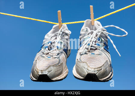 Pair of old trainers hanging on a clothes line. Stock Photo