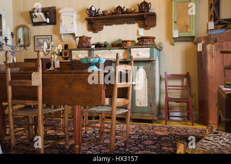 Antique wooden brown dining table and green and white buffet in antique store located in 1810 old house interior Stock Photo
