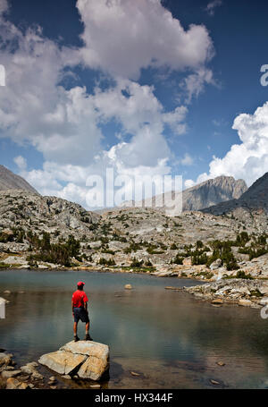 CA03100-00...CALIFORNIA - Hiker at a  tarn on Darwin's Bench in the Kings Canyon Wilderness. Stock Photo