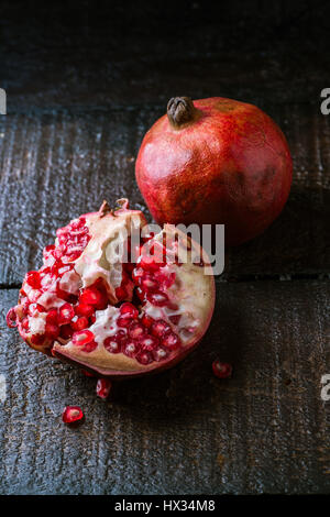 Sliced pomegranate on dark wood tabletop Stock Photo