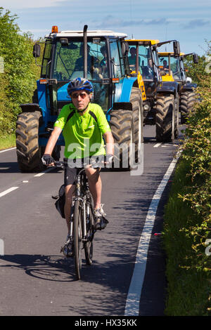 Cyclist in traffic, rural Yorkshire, England, UK Stock Photo