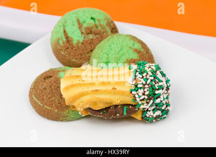 St. Patrick's Day, Easter, and spring season reflected in assortment of cookies with green accents on white plate. Stock Photo