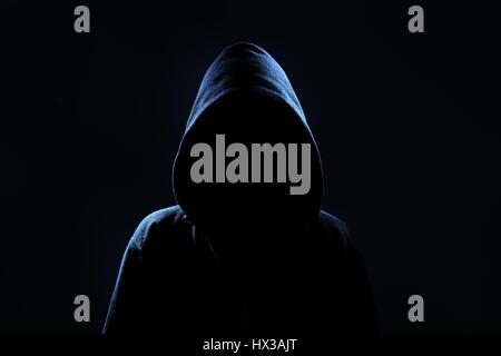 Mysterious, unknown person in the hood. Danger in darkness. Stock Photo