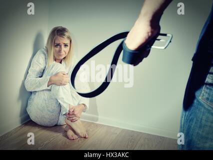 Woman afraid of her husband, who wants to beat her. Domestic violence. Stock Photo