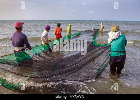 A group of Filipino fishermen haul their seine fishing net to shore at BayBay Beach in Roxas City, Panay Island, Philippines. Stock Photo