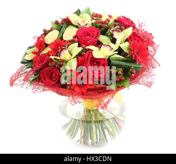 Flower arrangement in glass, transparent vase: red roses, orchids, red gerbera daisies. Isolated on white background. Floristic composition, design a  Stock Photo