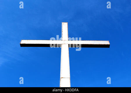 Metallic cross against blue sky Stock Photo