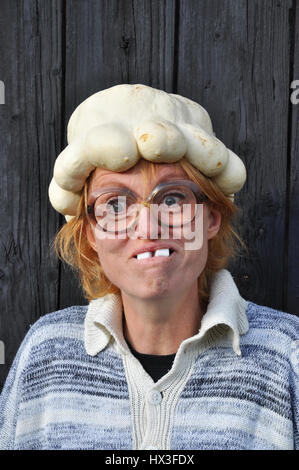 Bizarre woman with a pumpkin on her head. Stock Photo