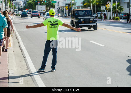 Miami Beach Florida,Collins Avenue,street scene,traffic,man men male,parking lot,garage,parking attendant,tee t-shirt,advertising,pointing,job,FL17021 Stock Photo