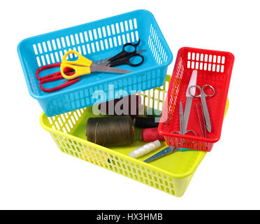 Colorful plastic baskets for domestic use, little household items in small boxes containers, spools of thread, scissors, manicure set, isolated on whi Stock Photo