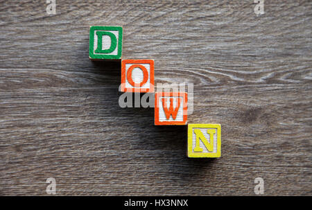 Word DOWN written with wood block letter alphabet Stock Photo