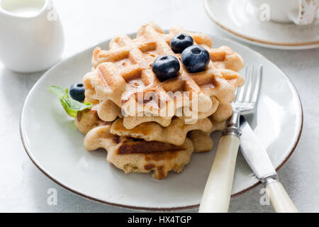 Belgian waffles with blueberries and honey on a plate, closeup view Stock Photo