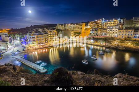 Xlendi, Gozo - Night photograph of Malta's most beautiful mediterranean town with busy night life, restaurants, hotels and moon light on the island of Stock Photo