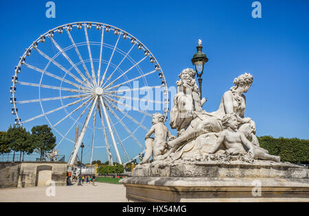 France, Paris, classic statuary at the Tuileries Gardens against the backdrop of the Grand Carousel Ferries Wheel Stock Photo