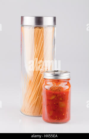 Jar of spaghetti and jar of tomato sauce isolated on white background. Stock Photo