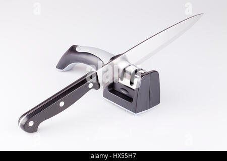 knife and knife sharpener musat on white surface. Knife and sharpening steel isolated on white background. Stock Photo