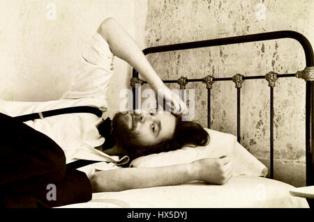 Retro man in doubt on bed Stock Photo