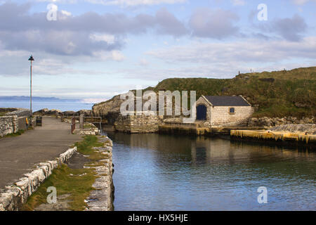 The small boathouse and slipway at Ballintoy harbor on the North Antrim Coast of Northern Ireland with its stone built boathouse on a day in spring Stock Photo