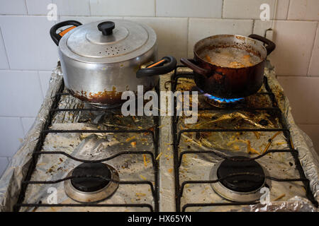 Dirty pans on filthy stove representing unhealthy eating habits with frying. Stock Photo