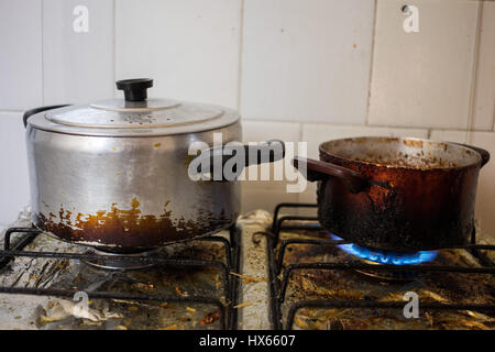 Dirty pans on filthy stove representing unhealthy eating habits with frying. Stock Photo