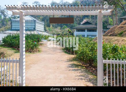 White Metal Entrance of Beautiful Roses Garden Stock Photo