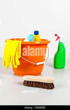 Scrubbing brush, bucket, housework gloves, spray bottle and other cleaning products on a floor ready to spring clean Stock Photo