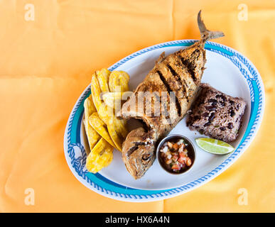 Whole Fish, Rice with Beans and Plantain Chips Stock Photo