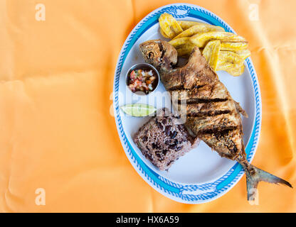 Whole Fish, Rice with Beans and Plantain Chips Stock Photo