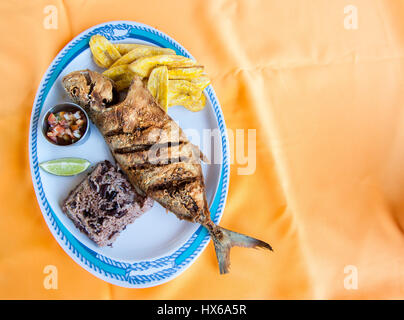 Whole Fish, Rice with Beans and Plantain Chips Stock Photo